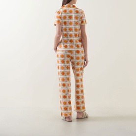 Model wearing Chelsea Peers Sunshine Tile Print Long Pyjama Set in Sunshine Grid, back view showing printed top and straight-leg trousers with ricrac