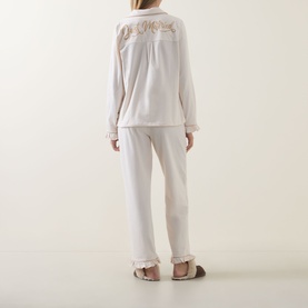 Model wearing Chelsea Peers Just Married Frill Long Pyjama Set in white with frill cuffs, contrast trims, and script slogan to the back.