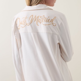 Model wearing Chelsea Peers Just Married Frill Long Pyjama Set in white, back view showing gold Just Married slogan script