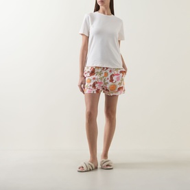 Model wearing Chelsea Peers Siesta Tiger Print Shorts Pyjama Set in Fiesta Siesta All Over Print, styled with white slider sandals