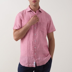 Model wearing Rodd & Gunn pink short-sleeve linen casual shirt with chest pocket, paired with navy trousers.