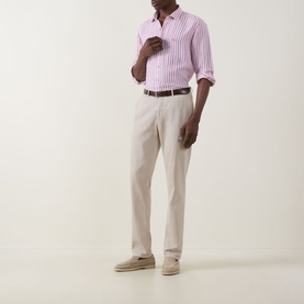 Model wearing Rodd & Gunn Seadown Stripe Shirt in RoseWater, styled with stone chinos, brown belt, and beige suede shoes.
