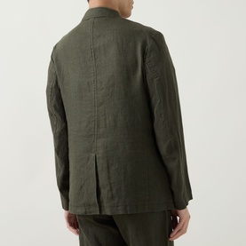 Model wearing Rodd & Gunn Campbell Island Single-Breasted Blazer in Dark Olive linen, rear view showing single vent and matching trousers.