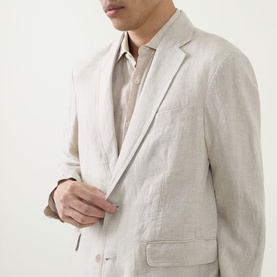 Model wearing Rodd & Gunn Campbell Island Single-Breasted Blazer in Oatmeal linen, showing notched lapels and button fastening, styled with a casual