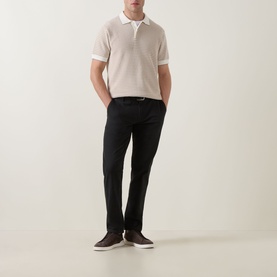 Model wearing Rodd & Gunn Oyster Island Striped Knitted Polo Shirt in Acorn, styled with black trousers and dark brown loafers.