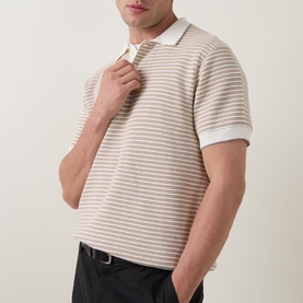 Model wearing Rodd & Gunn Oyster Island Striped Knitted Polo Shirt in Acorn, short sleeves, polo collar, paired with dark trousers