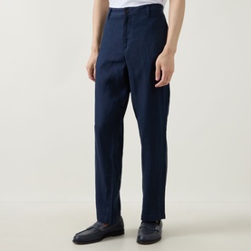 Model wearing Rodd & Gunn Spencer Bay Linen Trousers in navy, styled with black loafers. Straight-leg fit with belt loops.