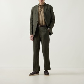 Model wearing Rodd & Gunn Spencer Bay Linen Trousers in Dark Olive with matching linen blazer, tan shirt, and dark suede loafers.