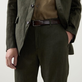 Model wearing Rodd & Gunn Spencer Bay Linen Trousers in Dark Olive, styled with matching linen blazer and brown leather belt.