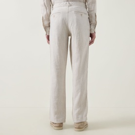Model wearing Rodd & Gunn Spencer Bay Linen Trousers in Oatmeal, shown from behind with rear buttoned jet pockets visible, styled with a linen shirt.