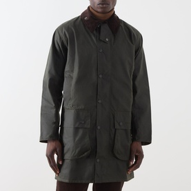 Model wearing Barbour green waxed cotton casual jacket with brown corduroy collar and large front patch pockets