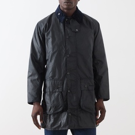Model wearing Barbour navy waxed cotton casual jacket with corduroy collar, front patch pockets, and button-front fastening