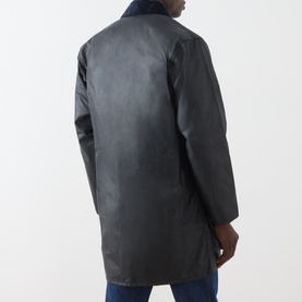 Model wearing Barbour navy waxed cotton casual jacket, rear view, styled with blue jeans