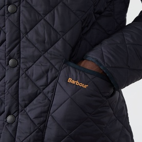 Barbour navy quilted casual jacket, close-up of side pocket with gold embroidered logo and press-stud fastening detail.