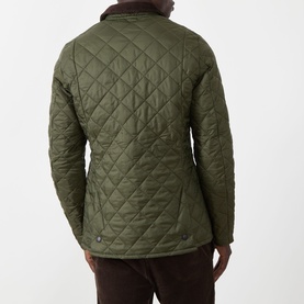 Model wearing Barbour Liddesdale Short Quilted Jacket in Olive, showing diamond quilt back, contrast corduroy collar, with brown trousers.