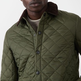 Model wearing Barbour Liddesdale Short Quilted Jacket in Olive, featuring diamond quilting, contrast brown corduroy collar and snap button fastening.