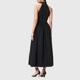Model wearing All Saints black halterneck midi dress with gathered skirt, styled with black lace-up heeled sandals, rear view.