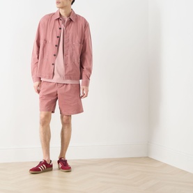 Model wearing Farah Vintage Mattison Denim Jacket in Dusty Red with matching shorts and burgundy trainers