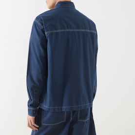 Model wearing Farah Vintage Mattison Denim Jacket in Aegean Blue, rear view showing contrast stitching and long sleeves, styled with matching denim