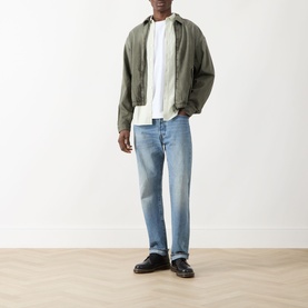 Model wearing Farah Vintage Brewer Logo Shirt in Soft Green with light-wash straight-leg jeans and black loafers.