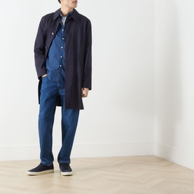 Model wearing Farah Vintage Brewer Logo Shirt in Aegean Blue, styled with navy mac coat, blue trousers and dark trainers.