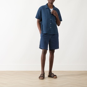 Model wearing Farah Vintage Olsen Textured Shirt in Aegean Blue with matching shorts and tan sandals.
