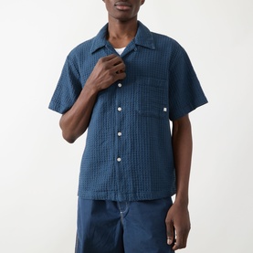 Model wearing Farah Vintage Olsen Textured Shirt in Aegean Blue, short sleeves, pointed collar, button front, styled with matching trousers