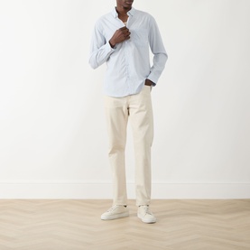 Model wearing Farah Vintage Blue Nickle casual shirt in 100% cotton, styled with cream chinos and white trainers.