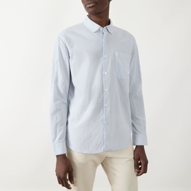 Model wearing Farah Vintage Casual Shirt in Blue Nickle, long-sleeve cotton with chest pocket, styled with cream trousers