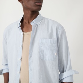 Model wearing Farah Vintage casual shirt in Blue Nickle, 100% cotton with chest pocket and button-down collar, styled over a beige vest.