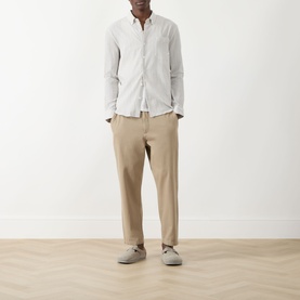 Model wearing Farah Vintage Stone Grey casual shirt, styled with beige tapered trousers and grey suede loafers.