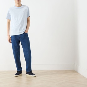 Model wearing Farah Vintage Castle Logo Striped T-Shirt in Blue Nickle, crew neck, short sleeves, styled with mid-blue jeans and navy trainers