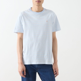 Model wearing Farah Vintage Castle Logo Striped T-Shirt in Blue Nickle, crew neck, short sleeves, styled with blue jeans.