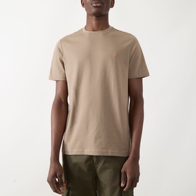 Model wearing Farah Vintage Danny Logo T-Shirt in Stone Grey, crew neck, short sleeves, styled with olive green shorts.