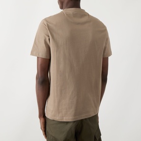 Model wearing Farah Vintage Danny Logo T-Shirt in Stone Grey, rear view, crew neck, short sleeves, styled with olive cargo trousers.