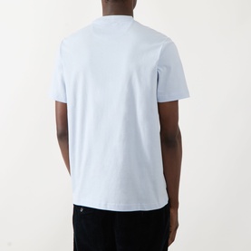 Model wearing pale blue crew neck short sleeve t-shirt, back view, styled with black trousers