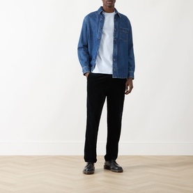 Model wearing blue denim overshirt, styled with white T-shirt, black trousers and black leather shoes.