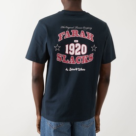 Model wearing Farah Vintage Caligo Logo T-Shirt in True Navy, showing back graphic with Farah Slacks 1920 collegiate print, short sleeves.
