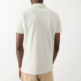 Model wearing Farah Vintage Blanes Logo Polo Shirt in Soft Green, rear view, with beige trousers visible.
