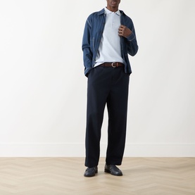 Model wearing Farah Vintage Blanes Logo Polo Shirt in Blue Nickle, styled with navy overshirt, tailored trousers and black loafers