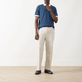 Model wearing Farah Vintage Clement Logo Contrast Collar Polo Shirt in Aegean Blue with cream trousers and dark loafers.