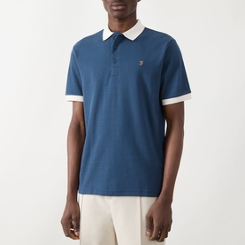 Model wearing Farah Vintage Clement Logo Contrast Collar Polo Shirt in Aegean Blue with white contrast collar and sleeve trim, paired with cream