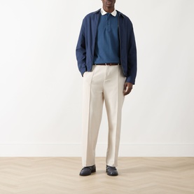 Model wearing Farah Vintage Clement Logo Contrast Collar Polo Shirt in Aegean Blue, styled with cream trousers and navy jacket.