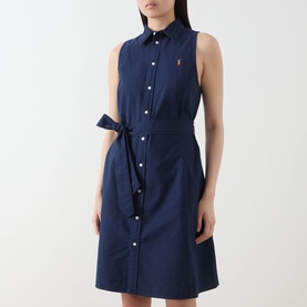 Model wearing Polo Ralph Lauren Polo Player Mini Shirt Dress in navy, sleeveless with button front, self-tie belt and embroidered logo