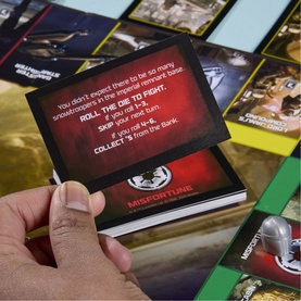 Star Wars: The Mandalorian and Grogu Monopoly board game close-up showing Misfortune card and Star Wars-themed game cards and board