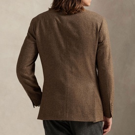 Model wearing a brown textured wool blazer, shown from the back, with a single vent and button cuffs