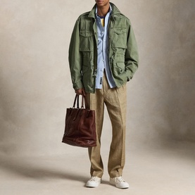 Model wearing Ralph Lauren Mint Olive casual jacket with khaki trousers, light blue shirt, white trainers, carrying dark brown tote bag.