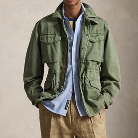 Model wearing Ralph Lauren Mint Olive casual jacket with chest pockets, styled over light blue shirt with tan trousers