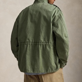 Model wearing Ralph Lauren Mint Olive casual jacket, rear view showing cinched waist detail and button placket, styled with beige trousers