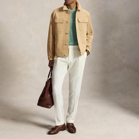 Model wearing Ralph Lauren Cafe Tan casual jacket, styled with mint green knit, white trousers and brown loafers, carrying brown leather tote bag.